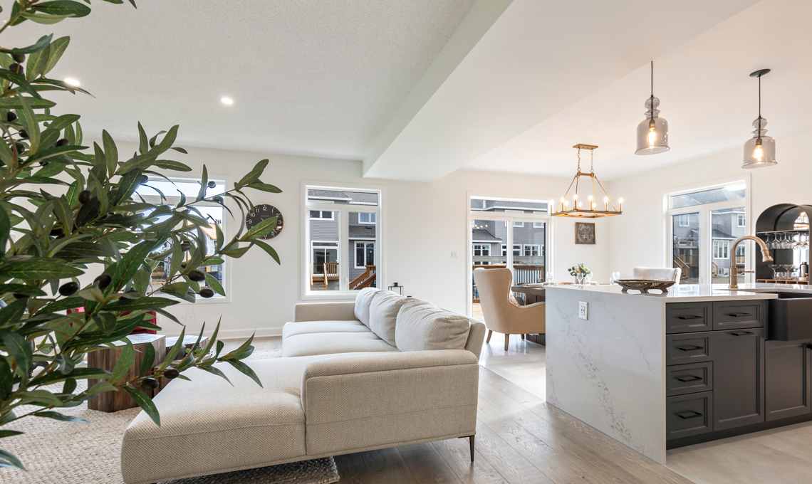 An spacious open-concept living room and kitchen in bright beiges.