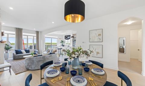 A spacious open-concept living and dining area with a kitchen seen int he background.