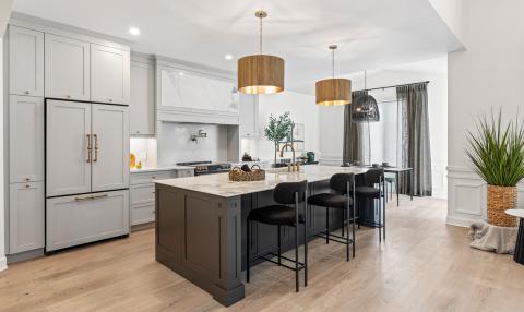 An open-concept kitchen with a large countertop island and a small table near a window.